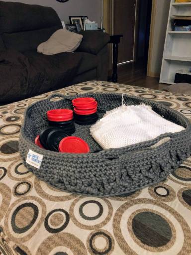 Finished tray basket with the checker and board pieces on the ottoman.