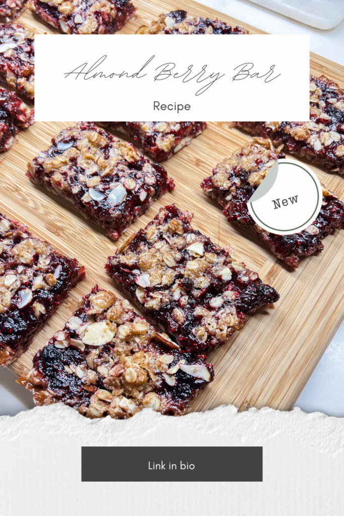 Almond Berry Bar Recipe New - Pinterest Pin Image is of the bars cut and sitting on a bamboo cutting board.