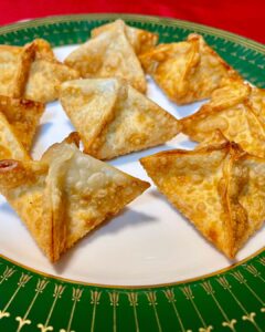 a green and white plate topped with crab rangoon