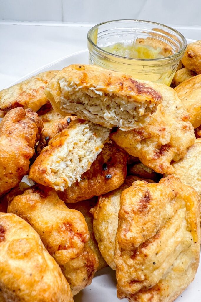 finished nuggets on a platter with one nugget cut in half to show the inside