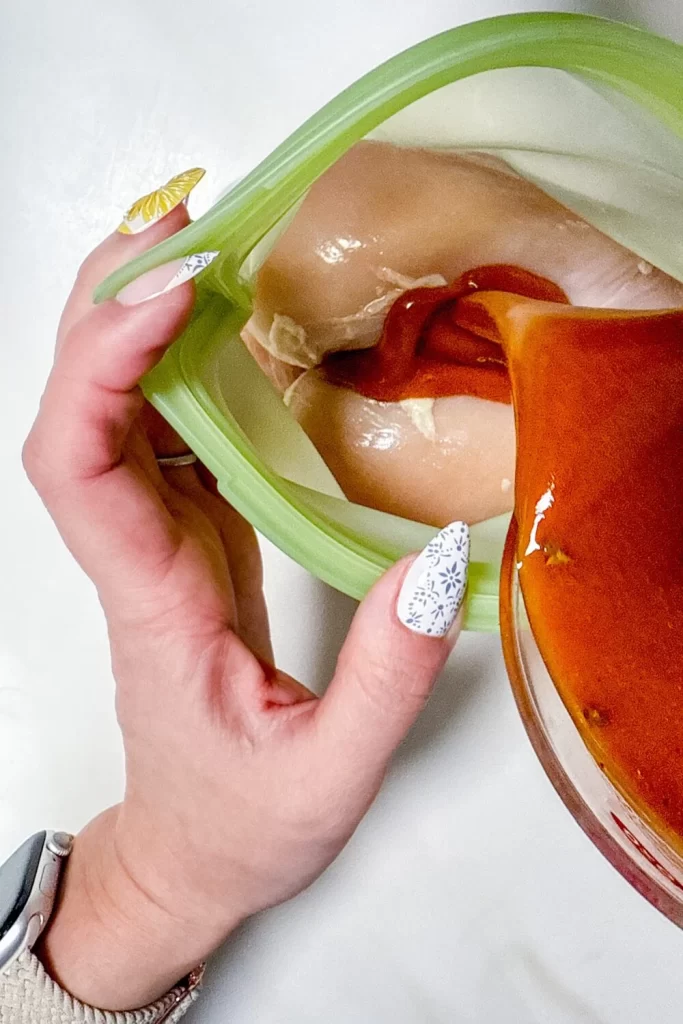 Marinade being poured over chicken in a bag 1
